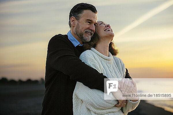 Cheerful mature woman enjoying with man at beach