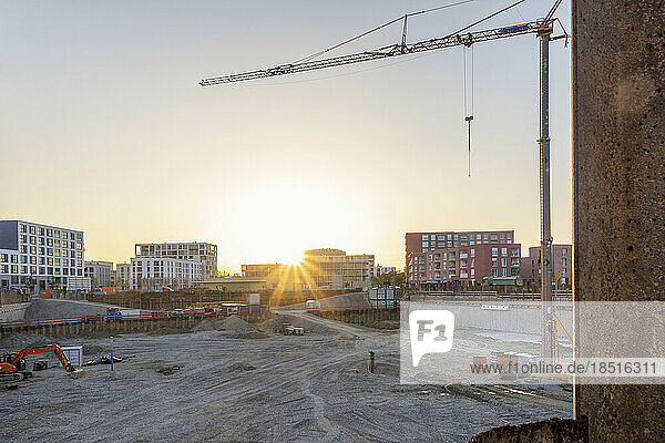 Construction site with buildings and crane at sunset