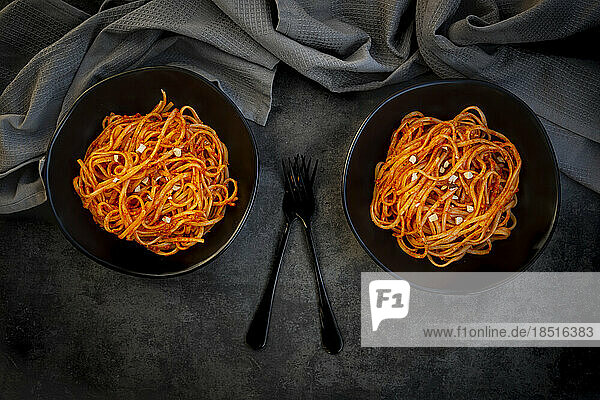 Studio shot of two bowls of vegan linguine with paprika almond sauce