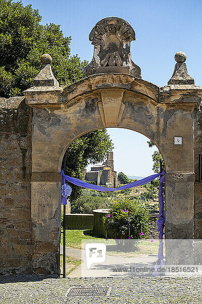 Italy  Lazio  Tuscania  Decorated entrance arch of garden in front of Chiesa di San Pietro