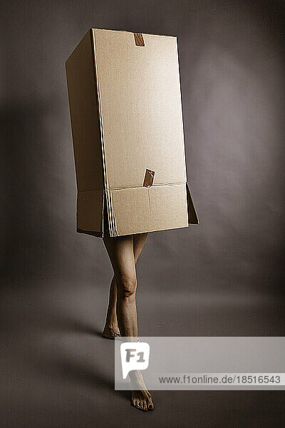 Woman inside cardboard box in studio