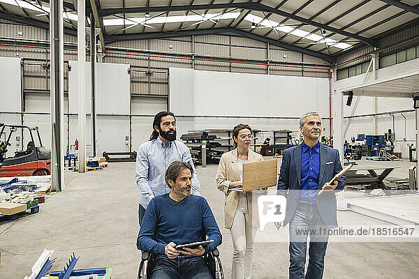 Disabled engineer having discussion with colleagues in factory