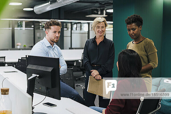 Businesswoman with colleagues having discussion in office