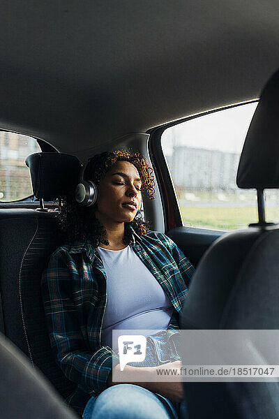 Young woman with eyes closed relaxing in car