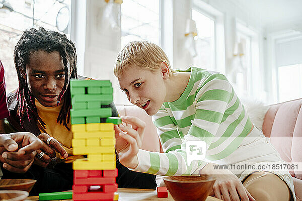 Blond young woman playing block removal game at home