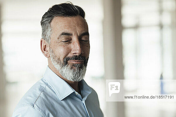 Smiling mature businessman with eyes closed