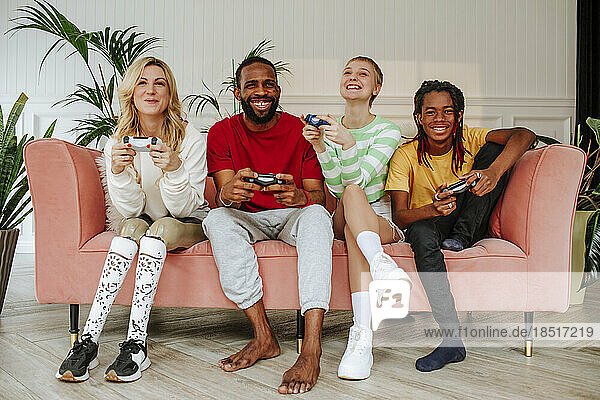 Diverse friends having fun together playing video game at home
