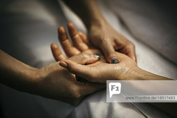 Massage therapist massaging woman's hand