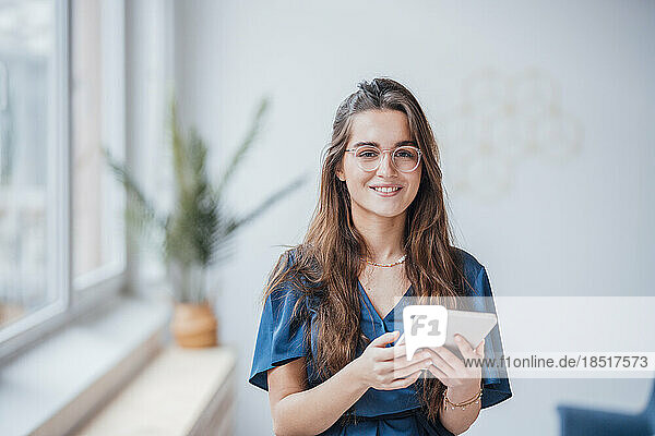 Young businesswoman standing with tablet PC