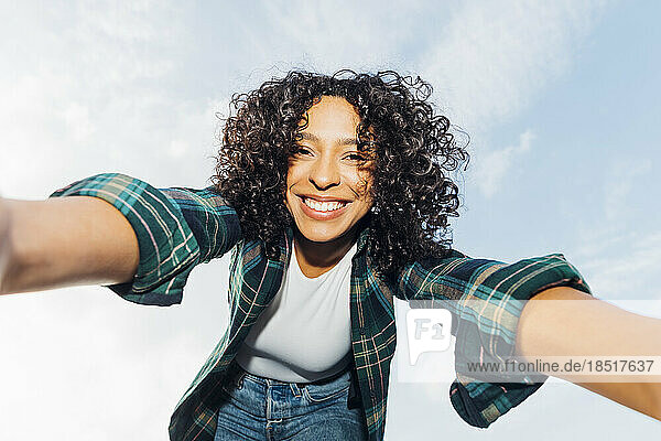 Glückliche junge Frau  die ein Selfie unter freiem Himmel macht