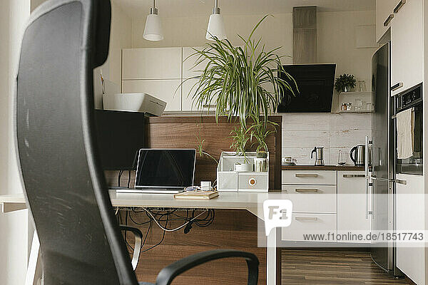 Laptop on desk in kitchen at home office
