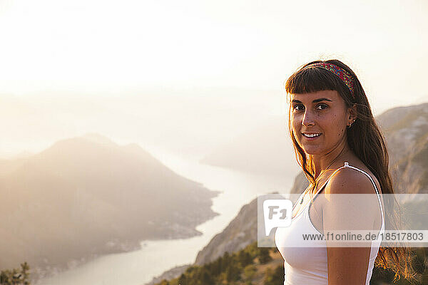 Smiling woman standing in front of mountains