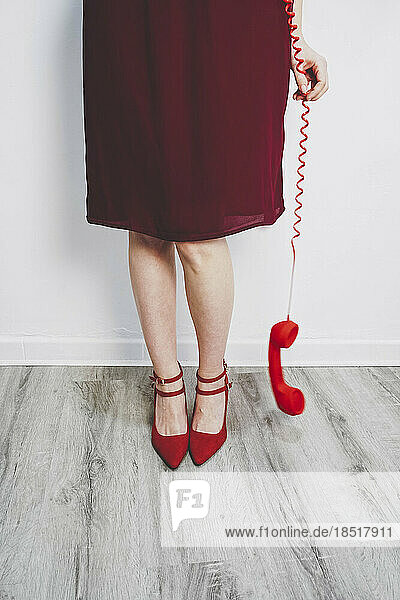 Woman holding red telephone receiver