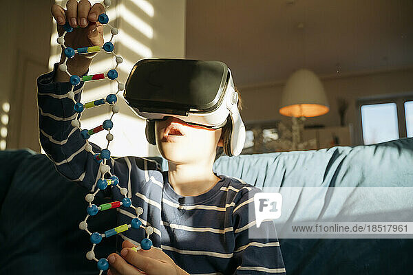 Boy wearing VR glasses examining DNA