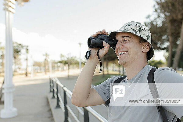Happy man looking through binoculars