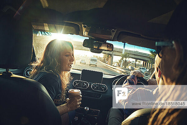 Friends talking to each on road trip in car