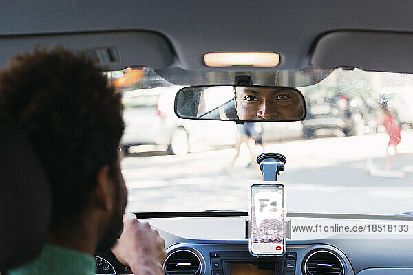 Mann schaut in den Rückspiegel eines Autos
