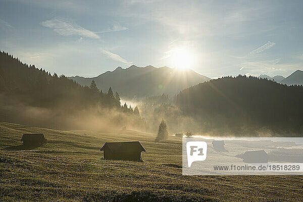 Germany  Bavaria  Secluded huts in Karwendel Mountains at foggy sunrise with Geroldsee Lake in background