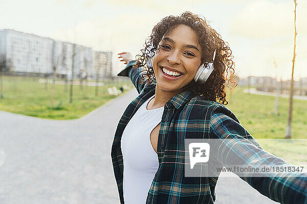 Fröhliche Frau tanzt mit kabellosen Kopfhörern