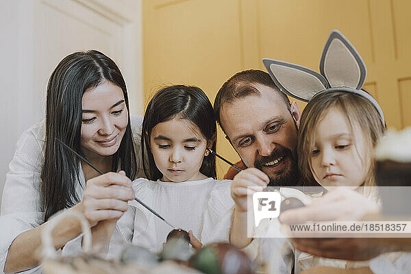 Parents and daughters decorating Easter eggs at home