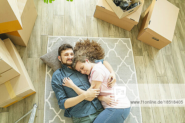 Couple resting on carpet in new home