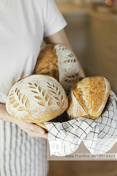 Woman holding freshly baked breads at home