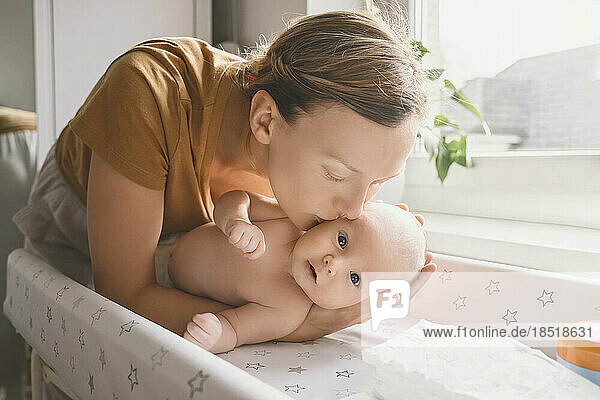 Mother kissing baby boy at home