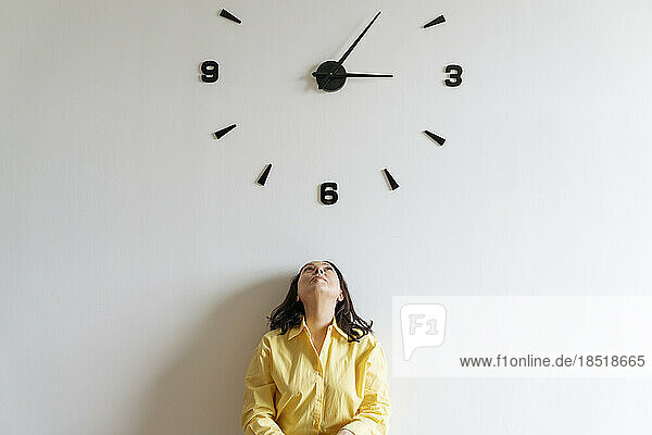 Woman under large clock on wall
