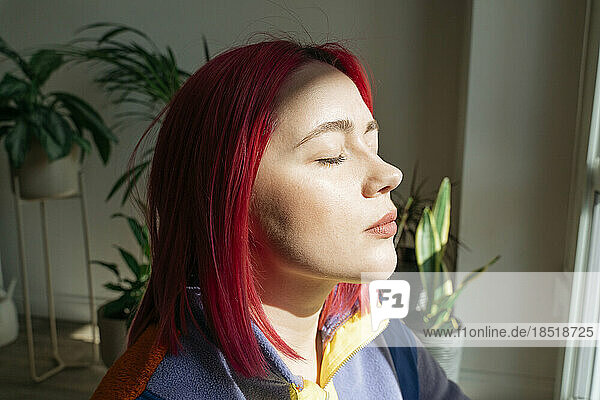 Woman with eyes closed enjoying sunlight on face