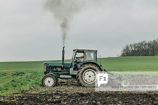 Farmer ploughing field with tractor