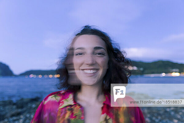 Happy young woman on beach at dusk