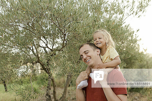 Glücklicher Vater und Tochter  die Spaß im Olivengarten haben
