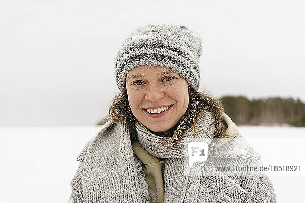 Happy woman wearing knit hat in winter