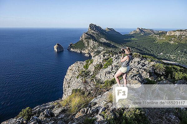 Wanderin blickt über felsige Klippen und Meer  Cap Formentor  Küstenlandschaft  Pollença  Mallorca  Balearen  Spanien  Europa