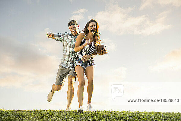 Man and woman playing ball in park 