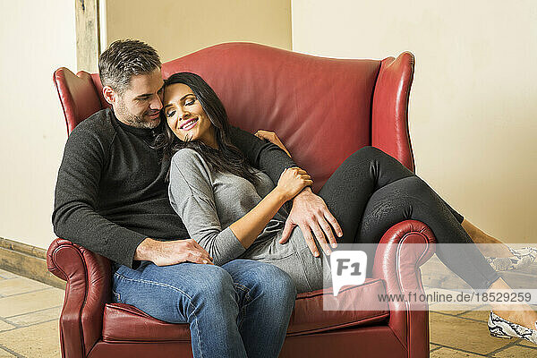 Couple relaxing in armchair together 