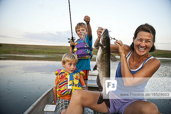 Mutter und zwei junge Söhne gehen angeln und fangen Fische; Valparaiso  Nebraska  Vereinigte Staaten von Amerika