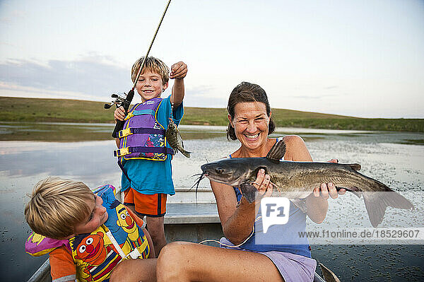 Mutter und zwei junge Söhne gehen angeln und fangen Fische; Valparaiso  Nebraska  Vereinigte Staaten von Amerika