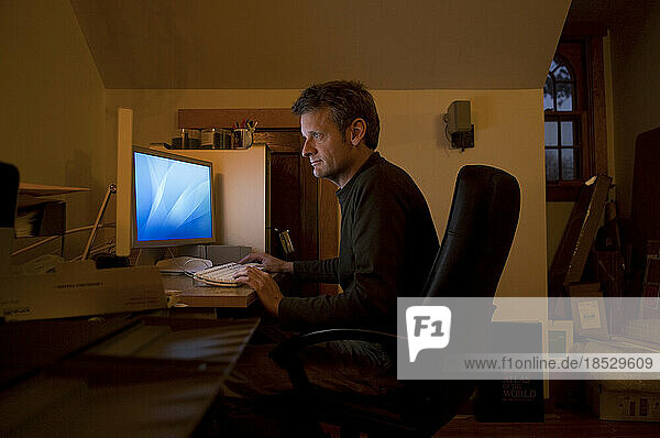 Mann arbeitet an einem Computer in einem Heimbüro; Lincoln  Nebraska  Vereinigte Staaten von Amerika