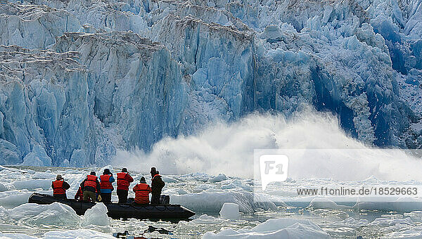 Ecotourists in an inflatable raft photograph South Sawyer Glacier calving in the Inside Passage  Tracy Arm-Fords Terror Wilderness; Inside Passage  Alaska  United States of America