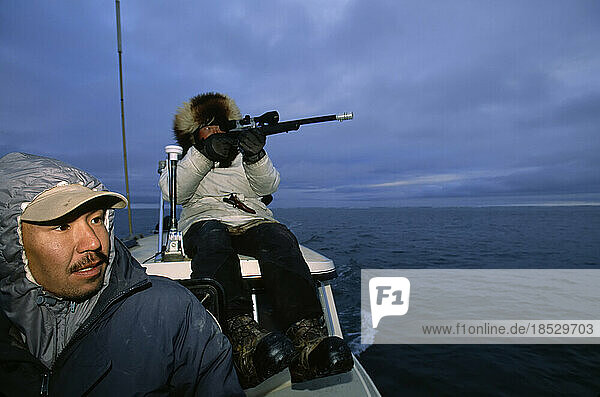 Inuit hunters in a boat  Alaska's North Slope area; North Slope  Alaska  United States of America