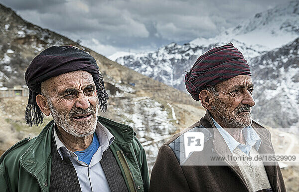 Portrait of two Kurdish men with snow-capped mountains in the background; Urkantakht  Kermanshah  Iran