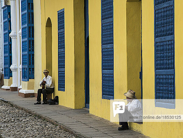 Ein Musiker unterhält einen Passanten in Trinidad  Kuba; Trinidad  Kuba