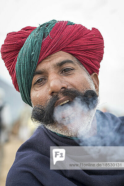 Nahaufnahme eines indischen Mannes  der Chillum-Rauch aus dem Mund bläst; Pushkar  Rajasthan  Indien