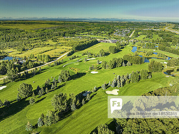 Luftaufnahme eines Golfplatzes mit Bergkette und blauem Himmel im fernen Hintergrund  südwestlich von Calgary  Alberta; Alberta  Kanada