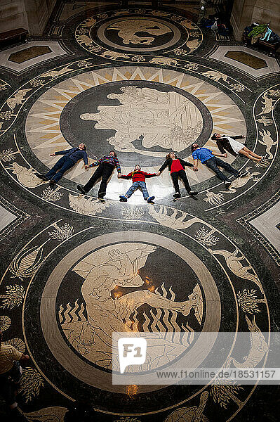 Reisegruppe liegt in einer Reihe auf dem dekorativen Boden der Rotunde im Nebraska State Capitol und blickt nach oben  um die Decke zu bewundern; Lincoln  Nebraska  Vereinigte Staaten von Amerika