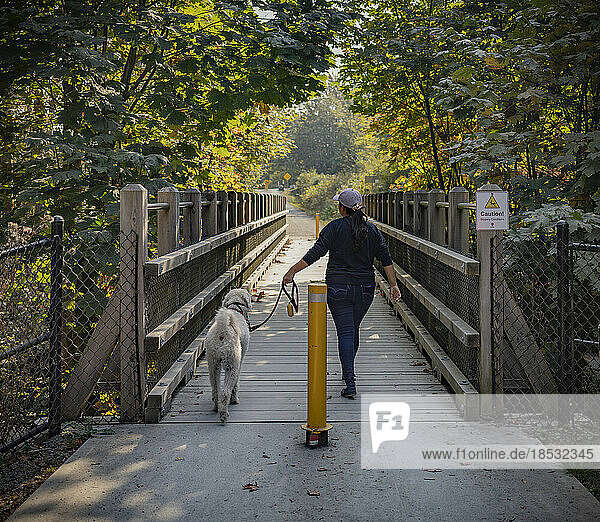 Frau geht mit ihrem Hund in einem Park spazieren; Vancouver Island  British Columbia  Kanada