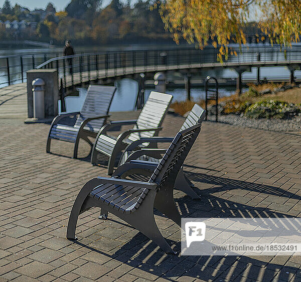 Stühle im Sonnenlicht entlang einer Uferpromenade; Victoria  British Columbia  Kanada