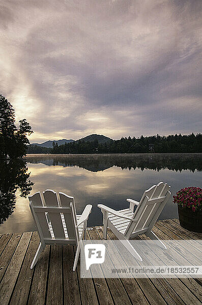 Ein Paar Adirondack-Stühle auf einem Steg an einem See in den Adirondack Mountains  New York  USA; New York  Vereinigte Staaten von Amerika