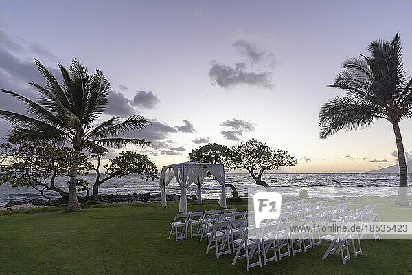 Vorbereitungen für eine Hochzeit im Freien bei Sonnenuntergang an der Küste einer hawaiianischen Insel mit Blick auf den Ozean und den Horizont; Maui  Hawaii  Vereinigte Staaten von Amerika